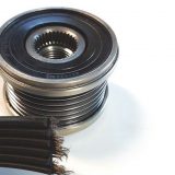 Nærbillede af en remskive og en slidt, flad sort rem på en hvid baggrund.