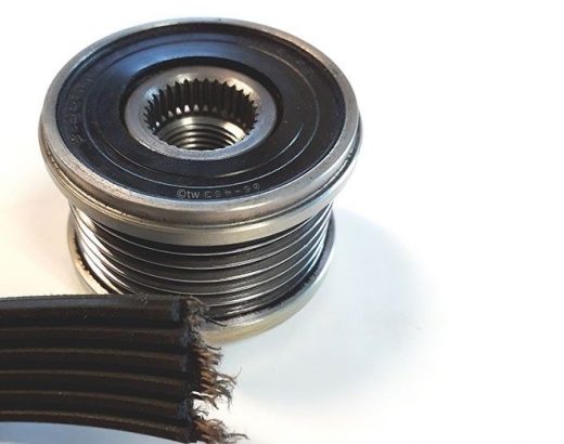 Nærbillede af en remskive og en slidt, flad sort rem på en hvid baggrund.